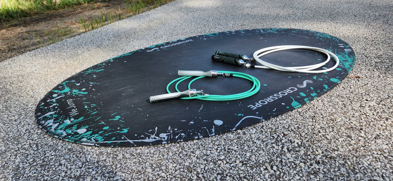 Two Crossrope jump ropes resting on a jump mat outdoors