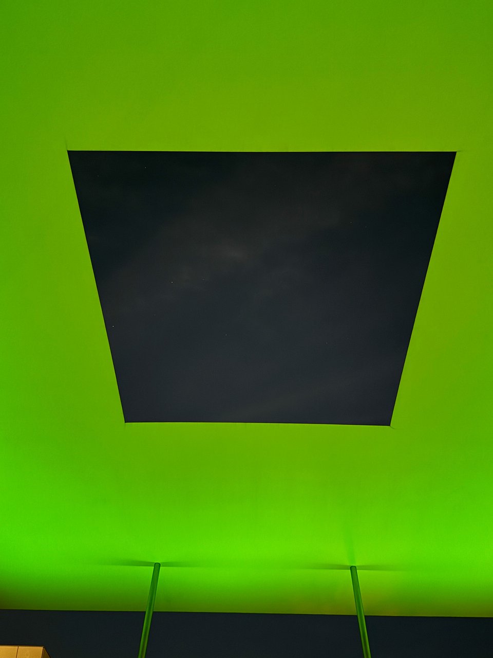 Photo of James Turrell's Skyspace exhibition. The sky is visible in a rectangular viewport with bright green-ish light around the viewport.