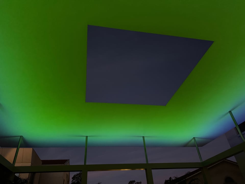 Photo of James Turrell's Skyspace exhibition. The sky is visible in a rectangular viewport with green-ish light around the viewport.
