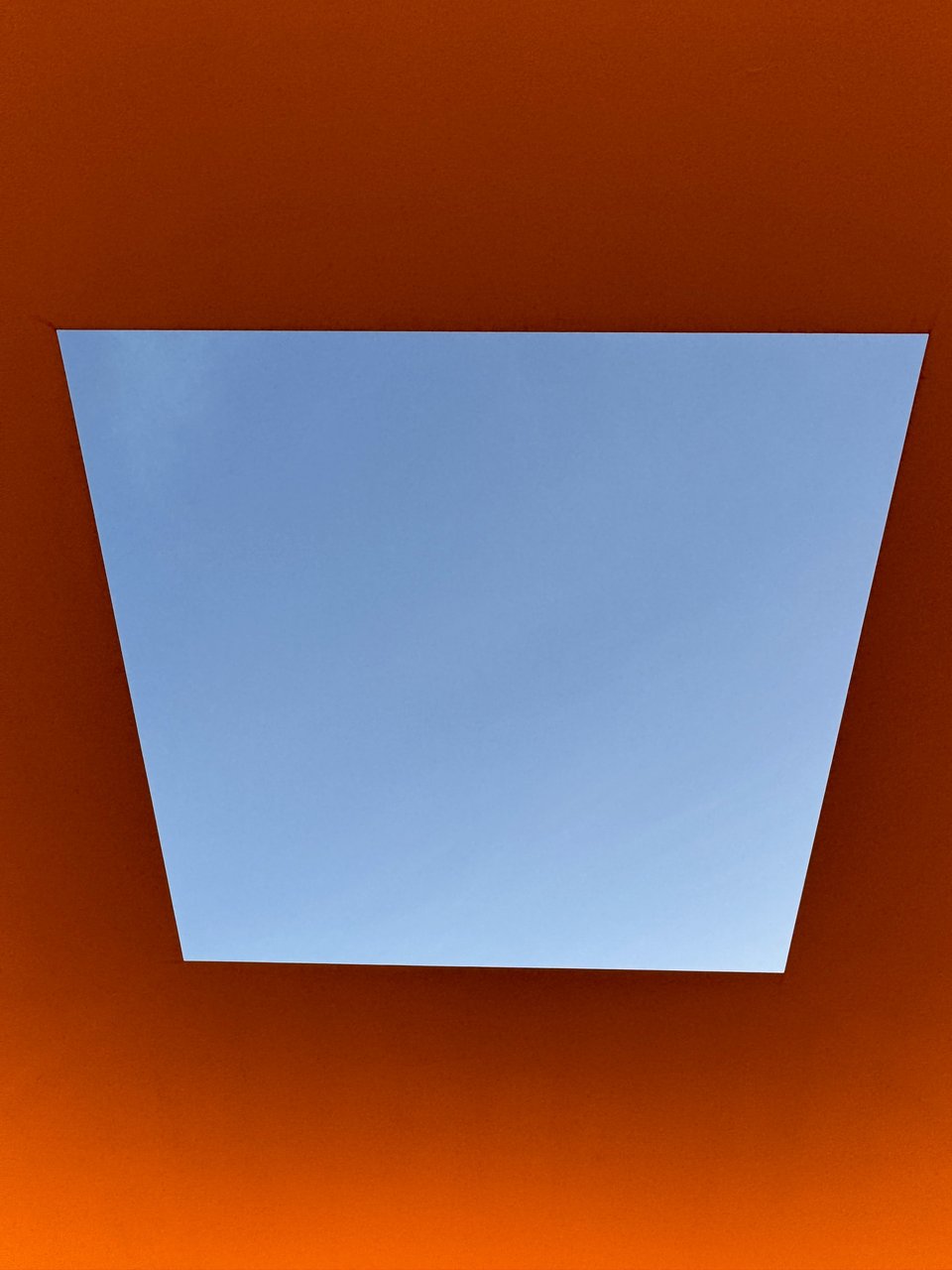 Photo of James Turrell's Skyspace exhibition. The sky is visible in a rectangular viewport with red-ish light around the viewport.
