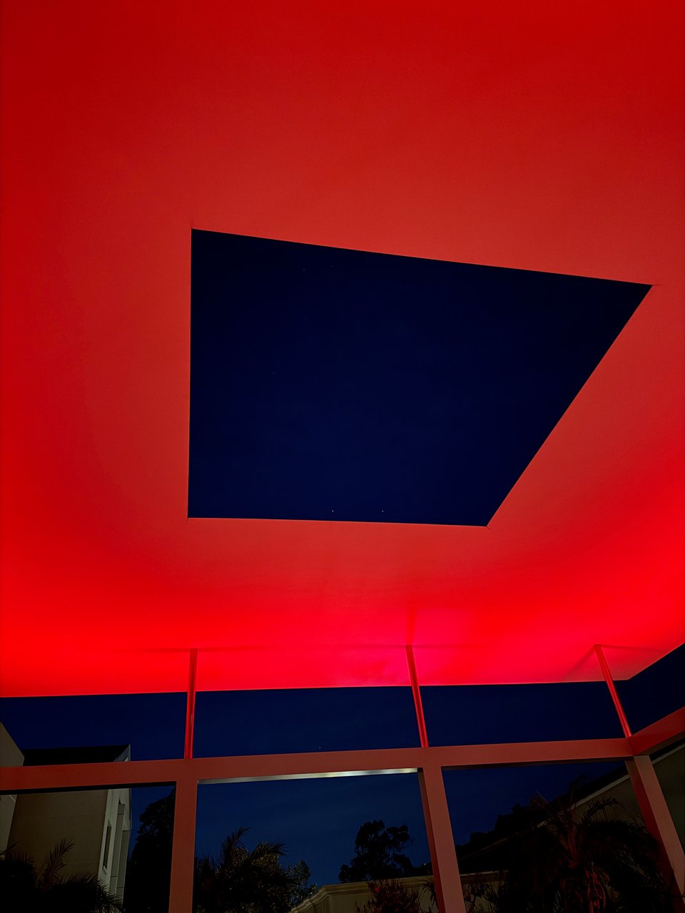 Photo of James Turrell's Skyspace exhibition. The sky is visible in a rectangular viewport with red-ish light around the viewport.