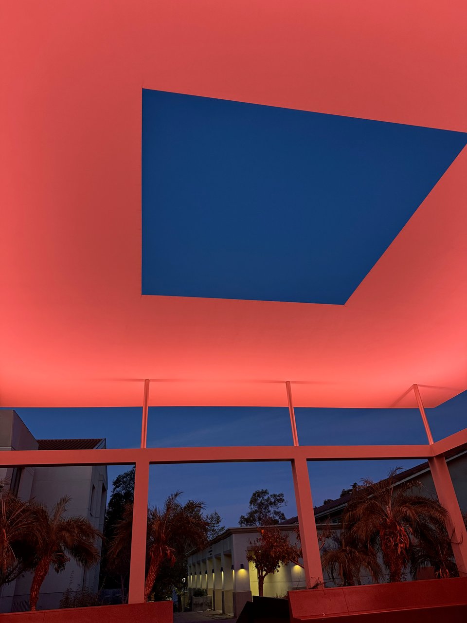 Photo of James Turrell's Skyspace exhibition. The sky is visible in a rectangular viewport with pink/coral-ish light around the viewport.