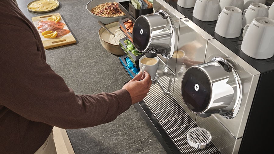 Person preparing coffee with a Nespresso Professional commercial coffee machine
