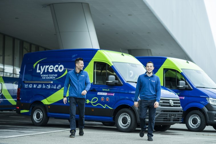 Two Lyreco delivery drivers standing beside Lyreco delivery vans