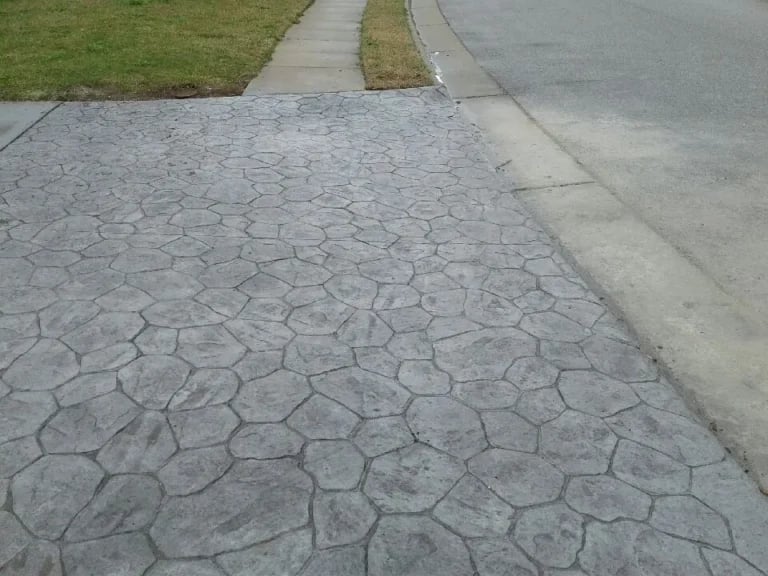 Decorative stamped concrete patio with elegant pattern installation in Virginia Beach residential backyard