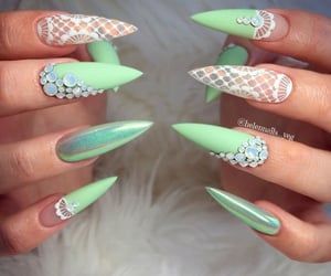 In this image show, the long green with the white color mermaid nails design.