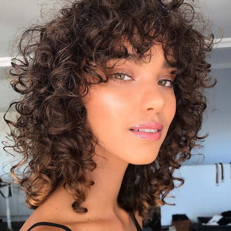 the image shows, curly shag haircut with bangs