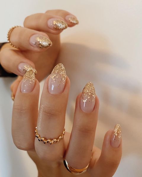 In this image show, the tip of gold nails with the attractive shimmer design.
