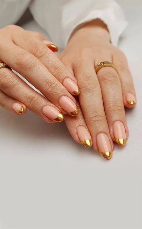 In this image show, the short cute pink base with the tip of gold nails design.