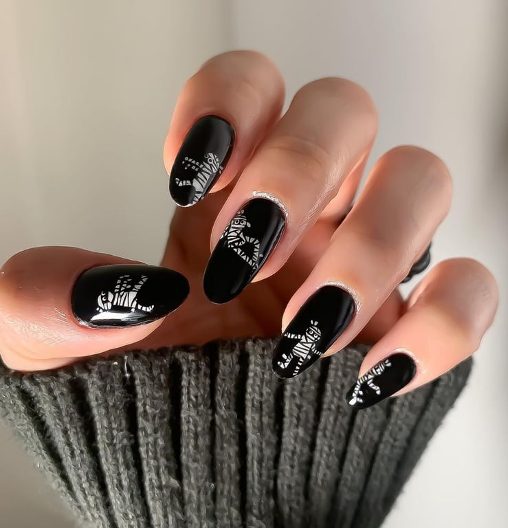 In this image show, the black color with small mummy nails design for holloween nails design.