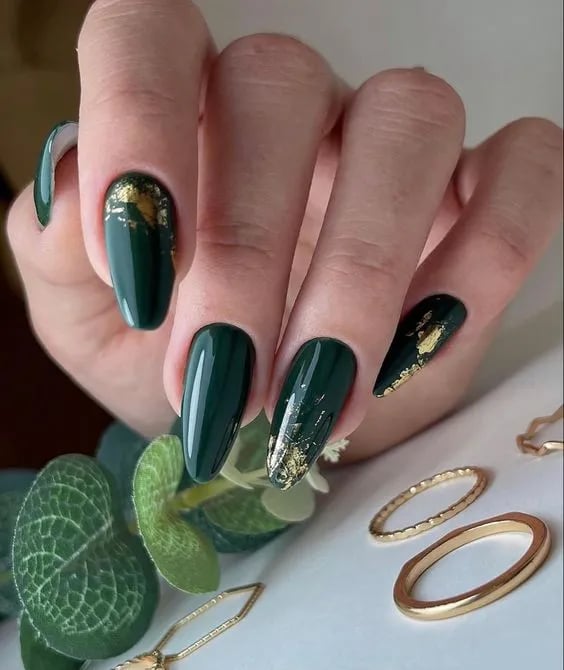 In this image show, the dark color long classic green color with the gold touch of spark nails design.