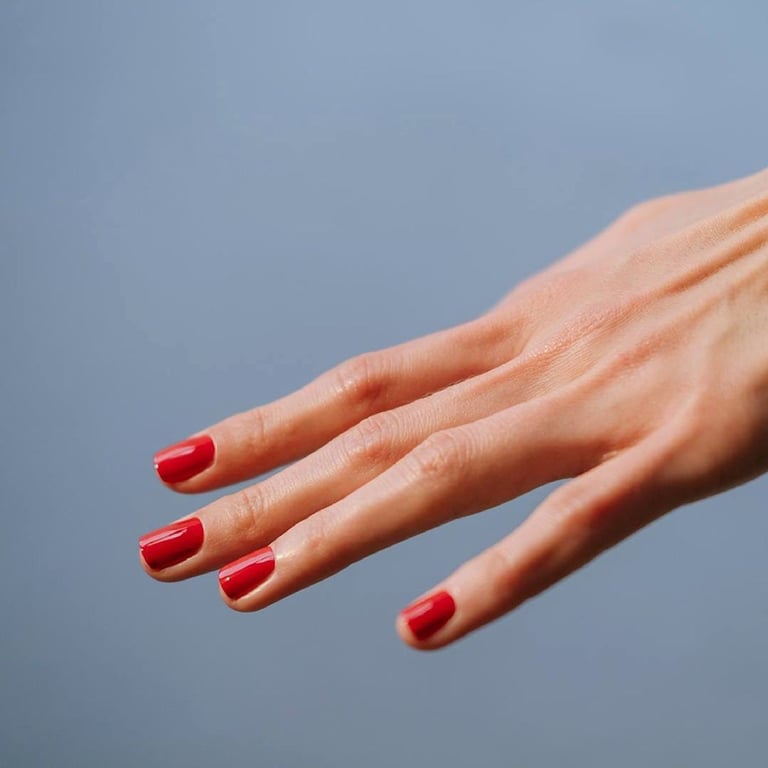 In this image show, the stright hand showing the red color of nails design.