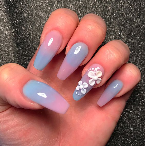 In this image show, the long pink and blue with white color flower nails design.