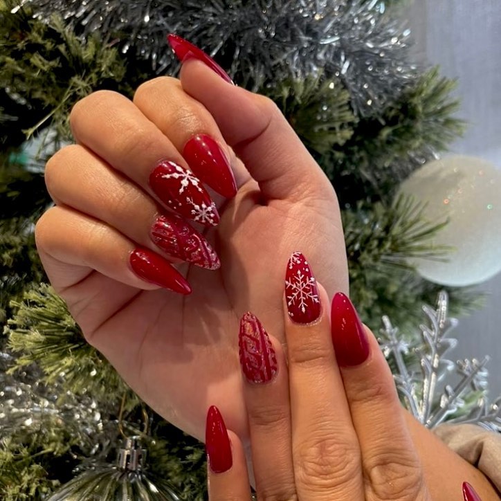 This image show the red and shnowfaks Christmas nails design