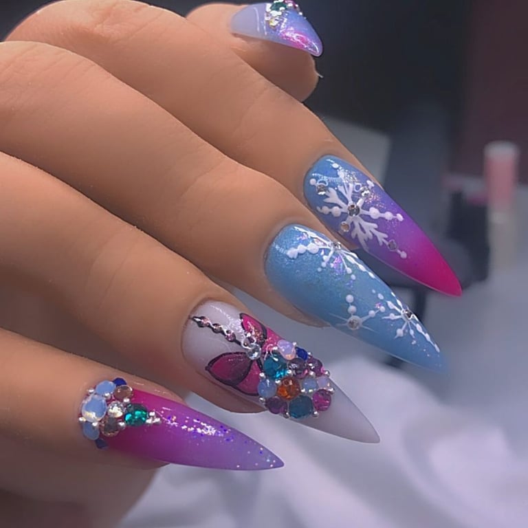 In this image show, the pink blue and with white snowflakes naile design.