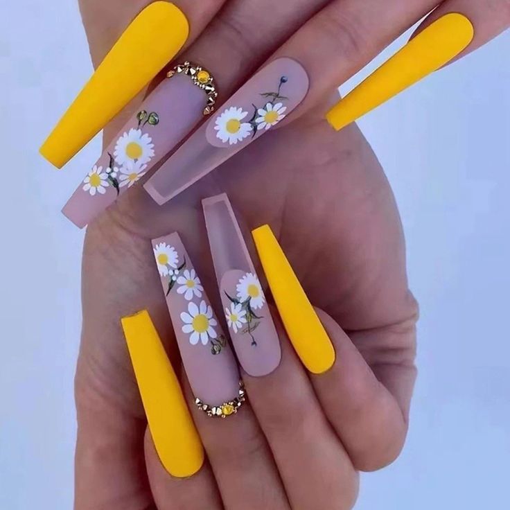In this image show, the long coffine shape yellow color with the cute little flowers nails design.