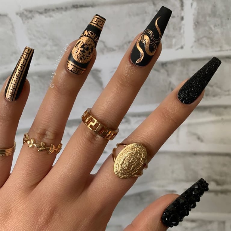 In this image show, the black color with the touch of gold in long nails design.
