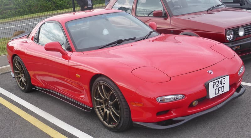 Mazda RX-7 FD (3rd generation) in red, front three-quarter view — right-hand-drive FD used as the RX-7 family stand-in