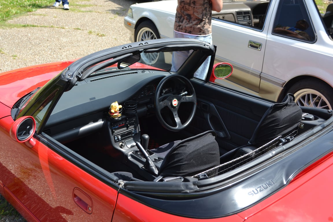 Interior of a red early-series Suzuki Cappuccino with the roof panels removed