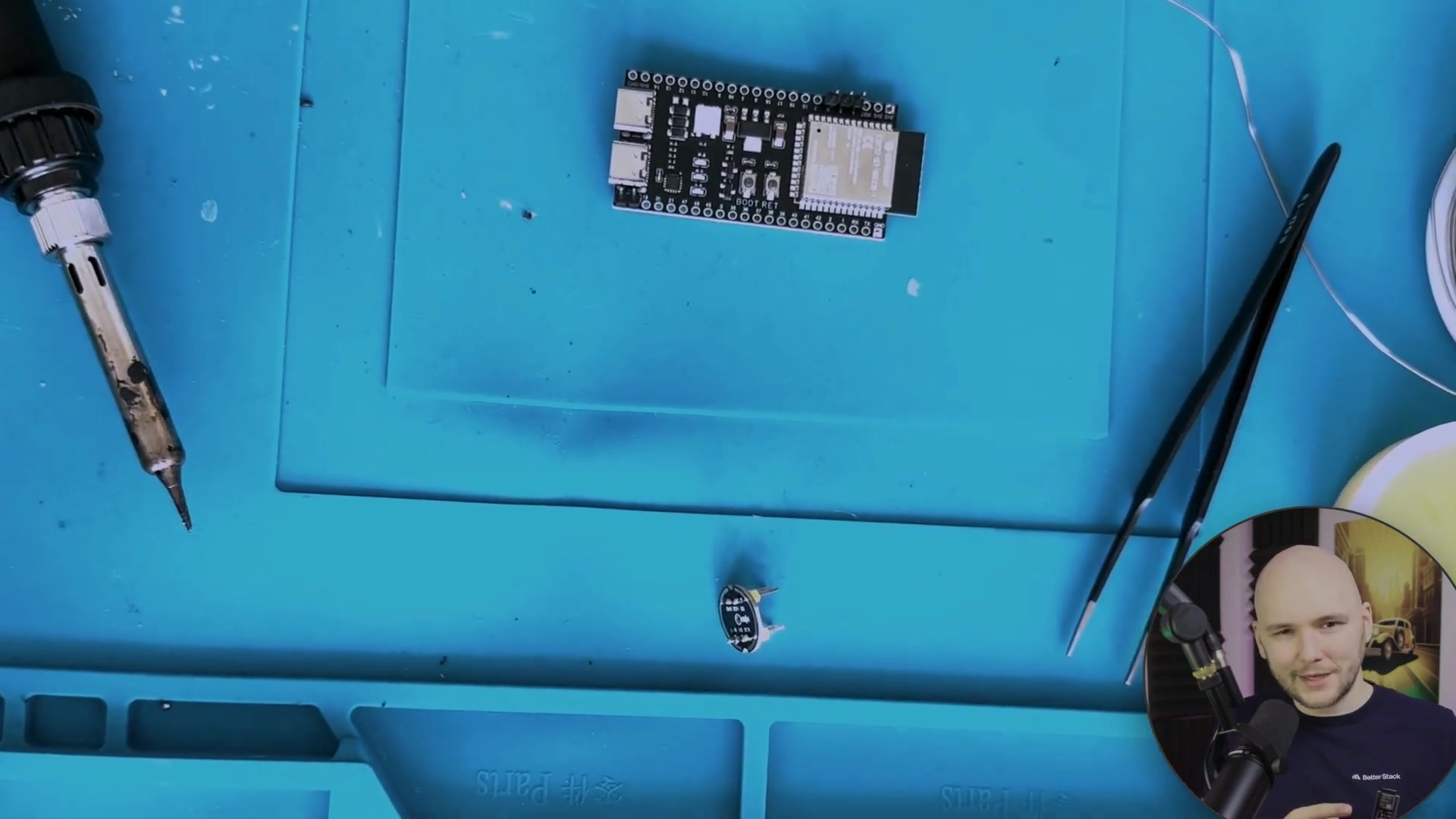 A top-down view of the ESP32-S3 board and components on a work mat.