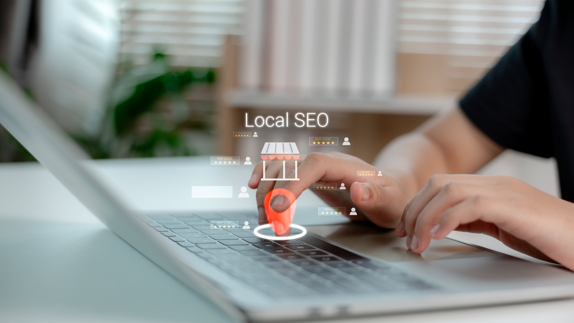 Hand touching virtual location pin on laptop keyboard with Local SEO text and customer reviews, symbolizing local business marketing, online presence, and digital search optimization.
