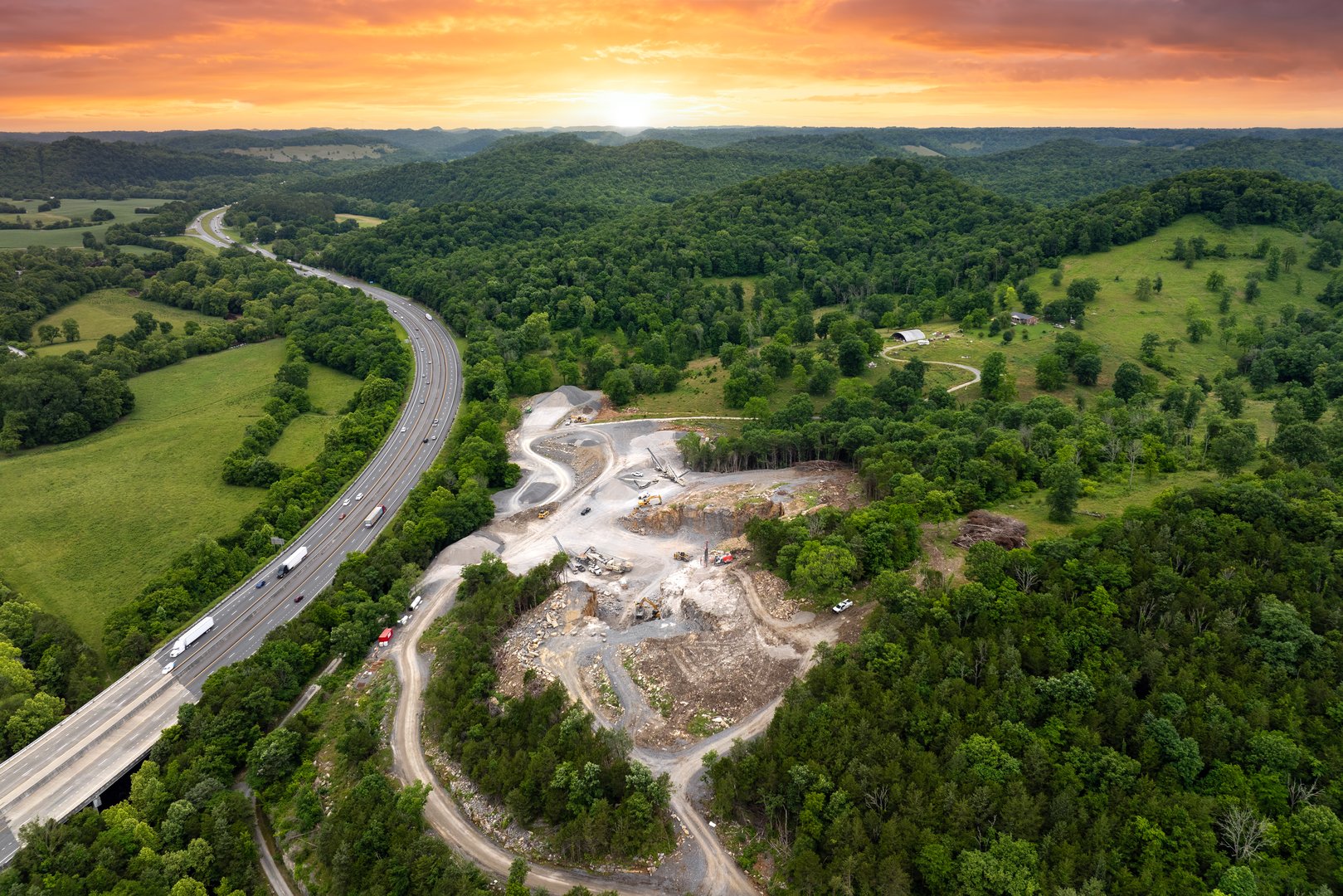 Industrial open-pit mining site with limestone quarry at mountain hillside.