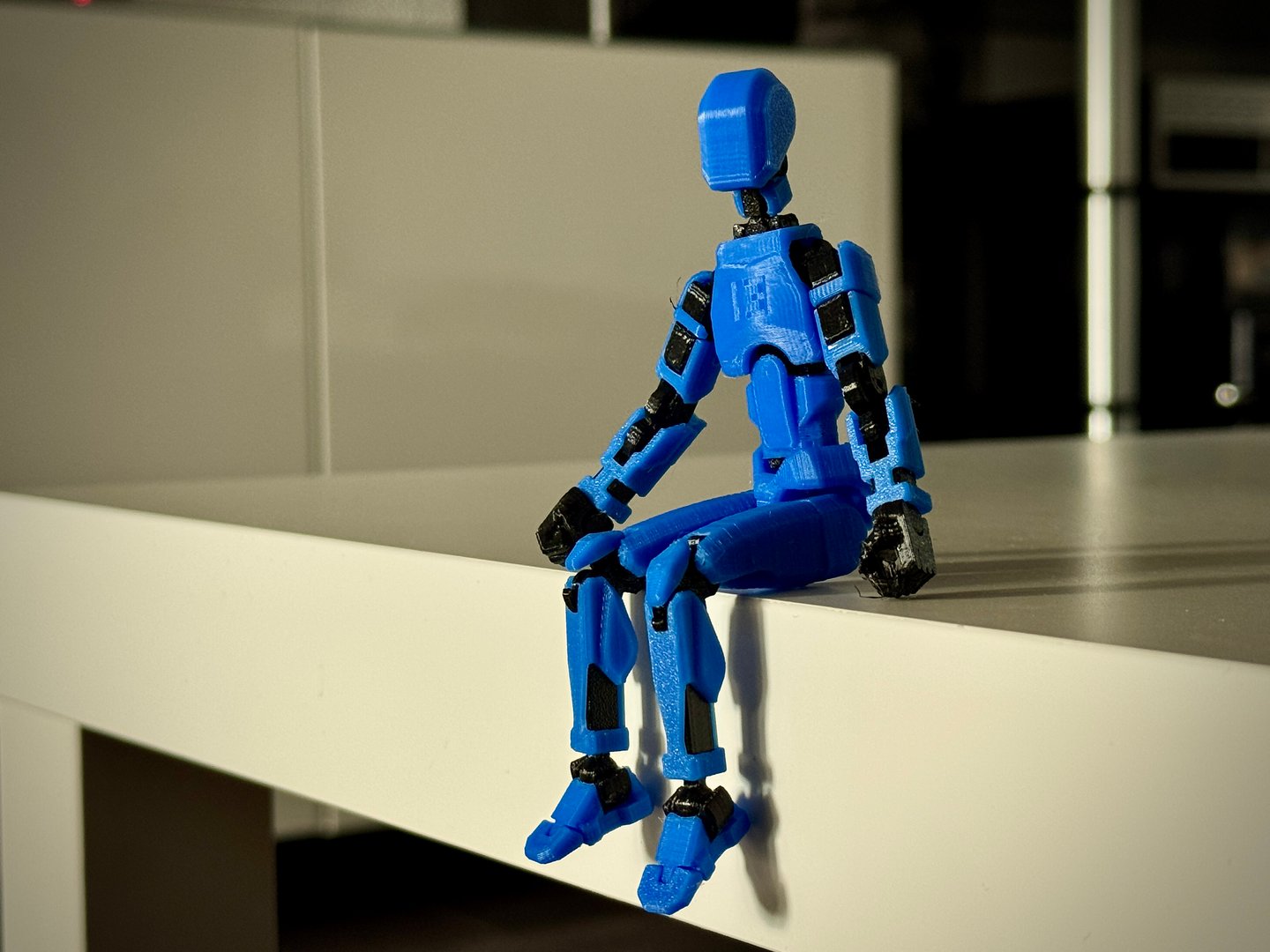 Close view of a friendly robot figure produced with desktop 3D printing, highlighting joints and mechanical details.