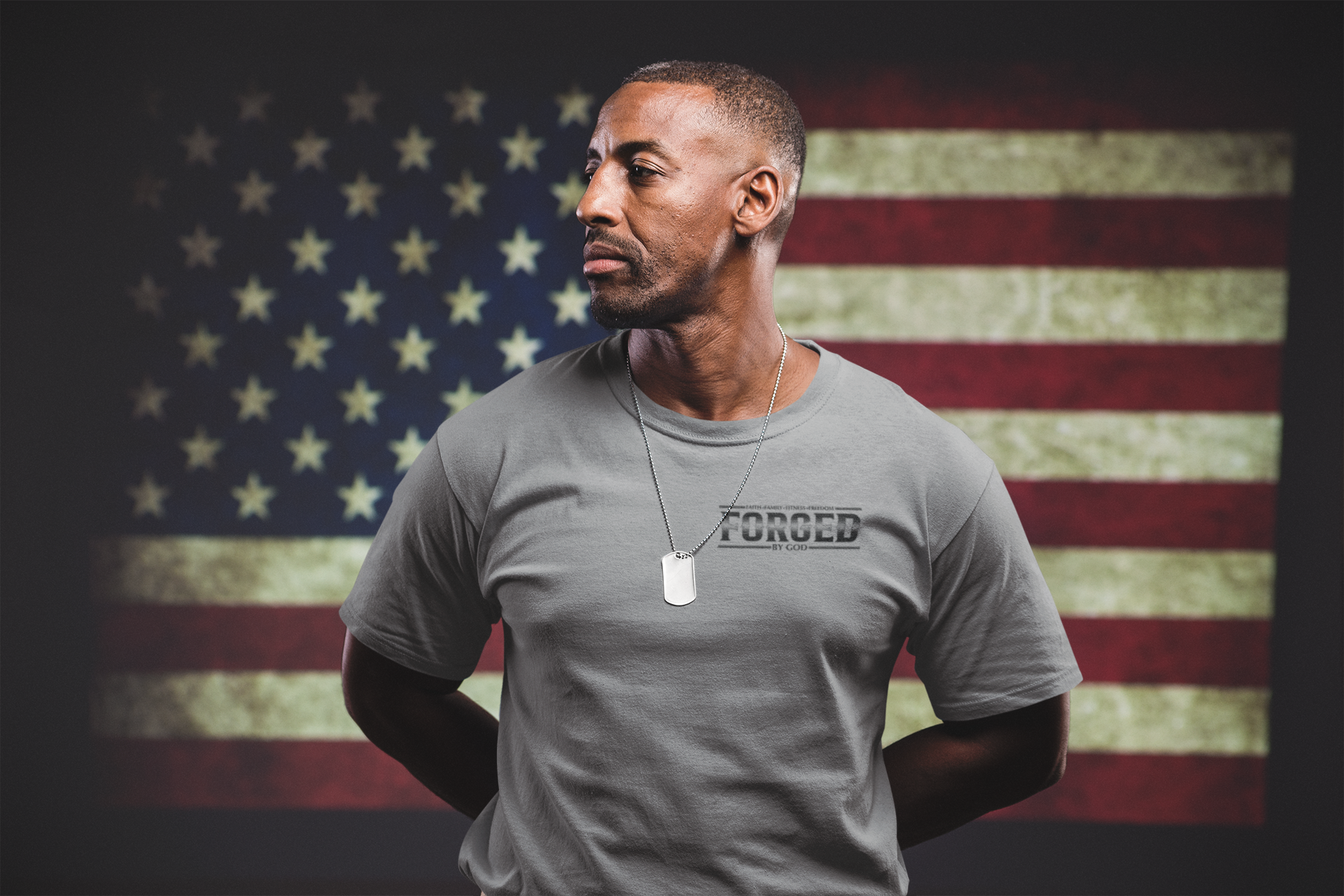 man wearing a tshirt mockup standing against an american flag