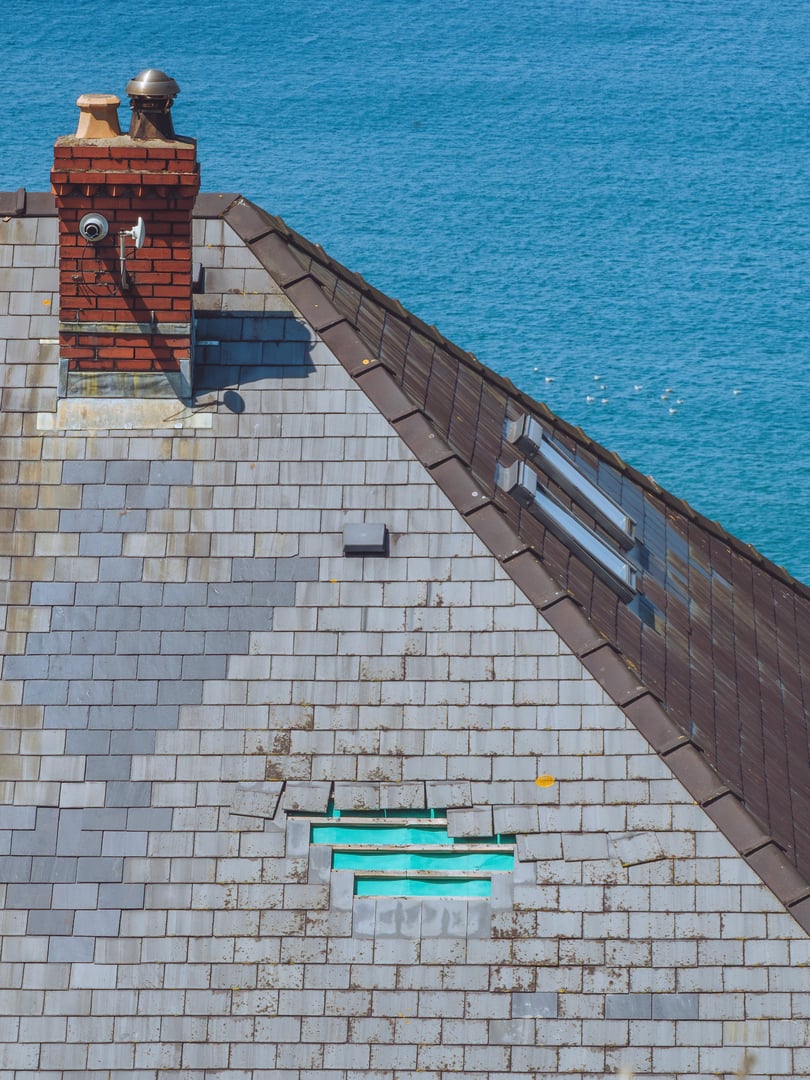 Loose root tiles in need of repair on a coastal property