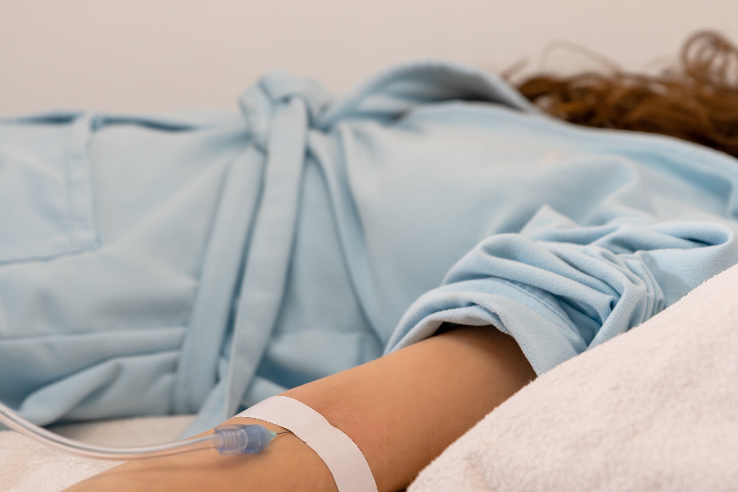 young woman on the hospital bed receiving a medical  perfusion