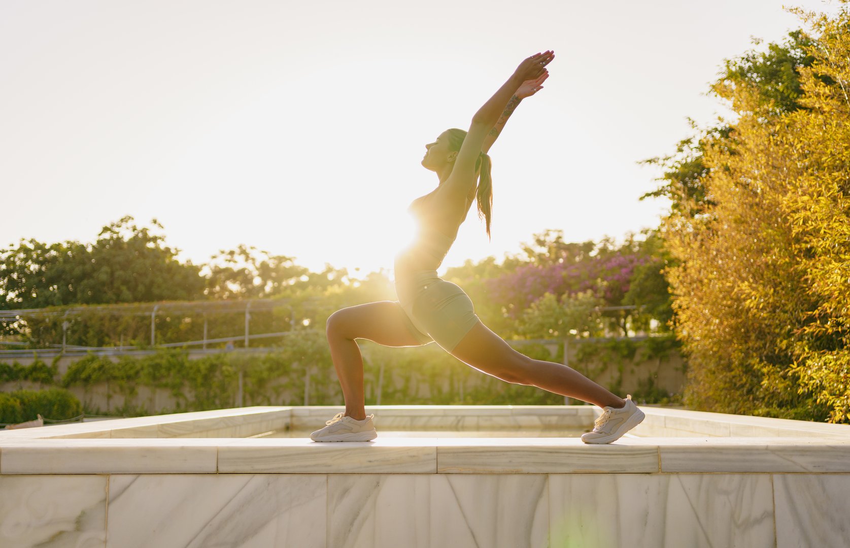 Silhouette of a woman practicing yoga during a stunning sunrise, embodying both strength and tranquility outdoors
