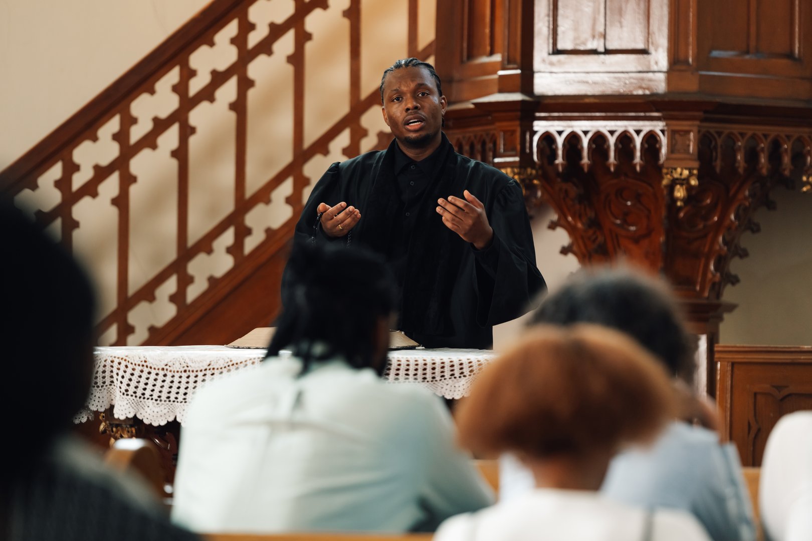 Young pastor passionately delivers a sermon to his congregation in a traditional church