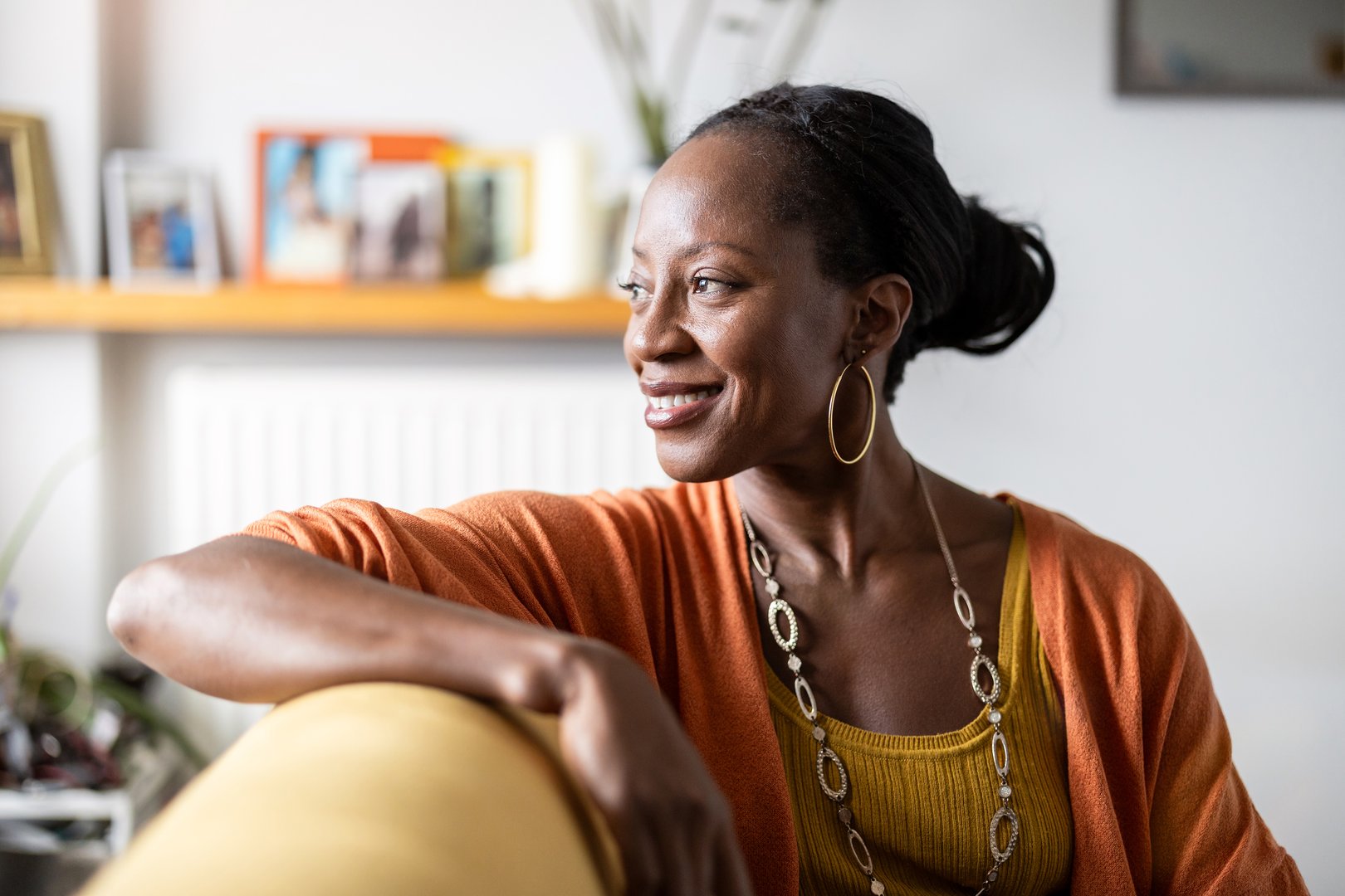 Portrait of smiling woman relaxing on sofa at home