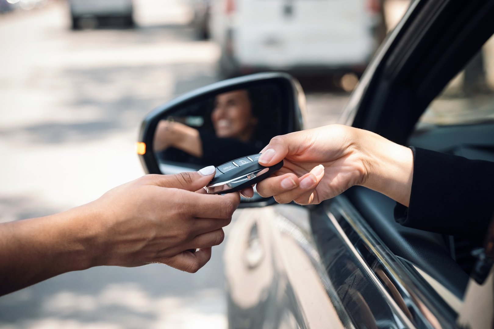 Shot of car rental agency employee giving car keys to beautiful young woman.