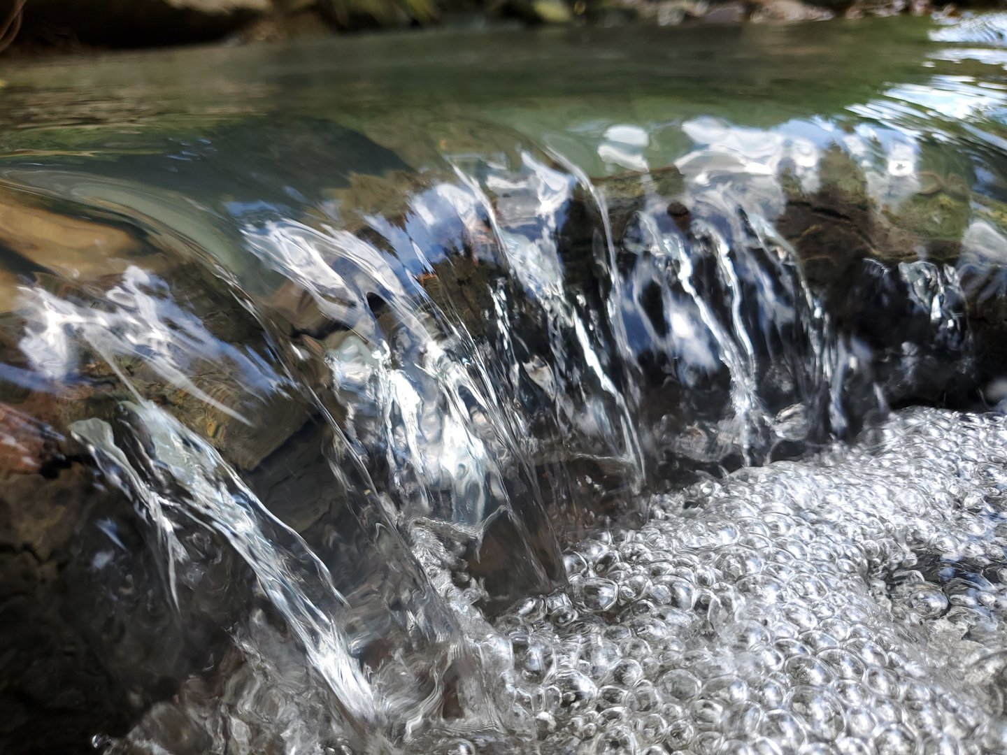 Close-up of a small crystal clear waterfall in a flowing stream in the Ozark mountains of Arkansas.