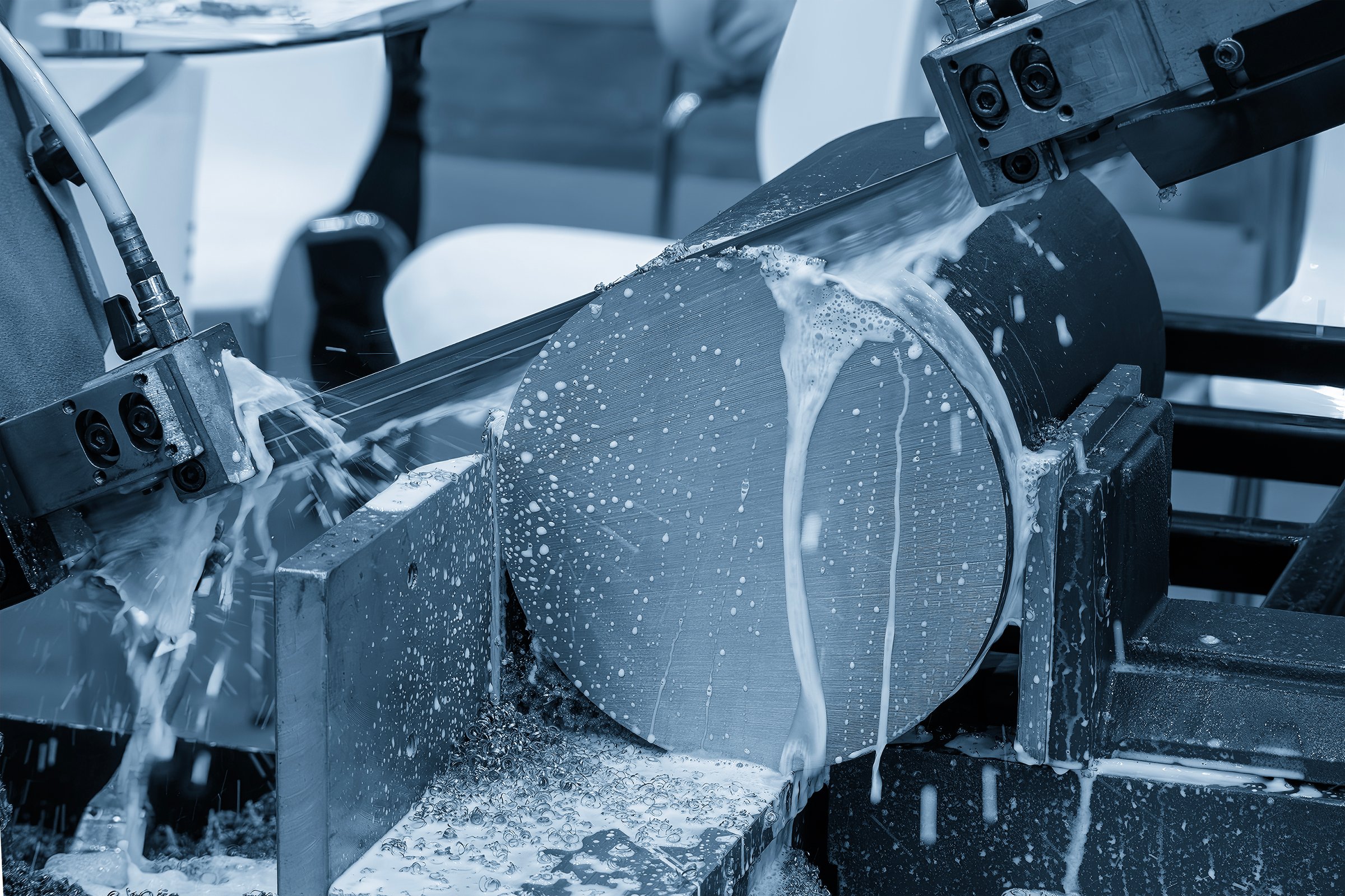 The band saw cutting machine cutting the metal shaft parts with coolant method.