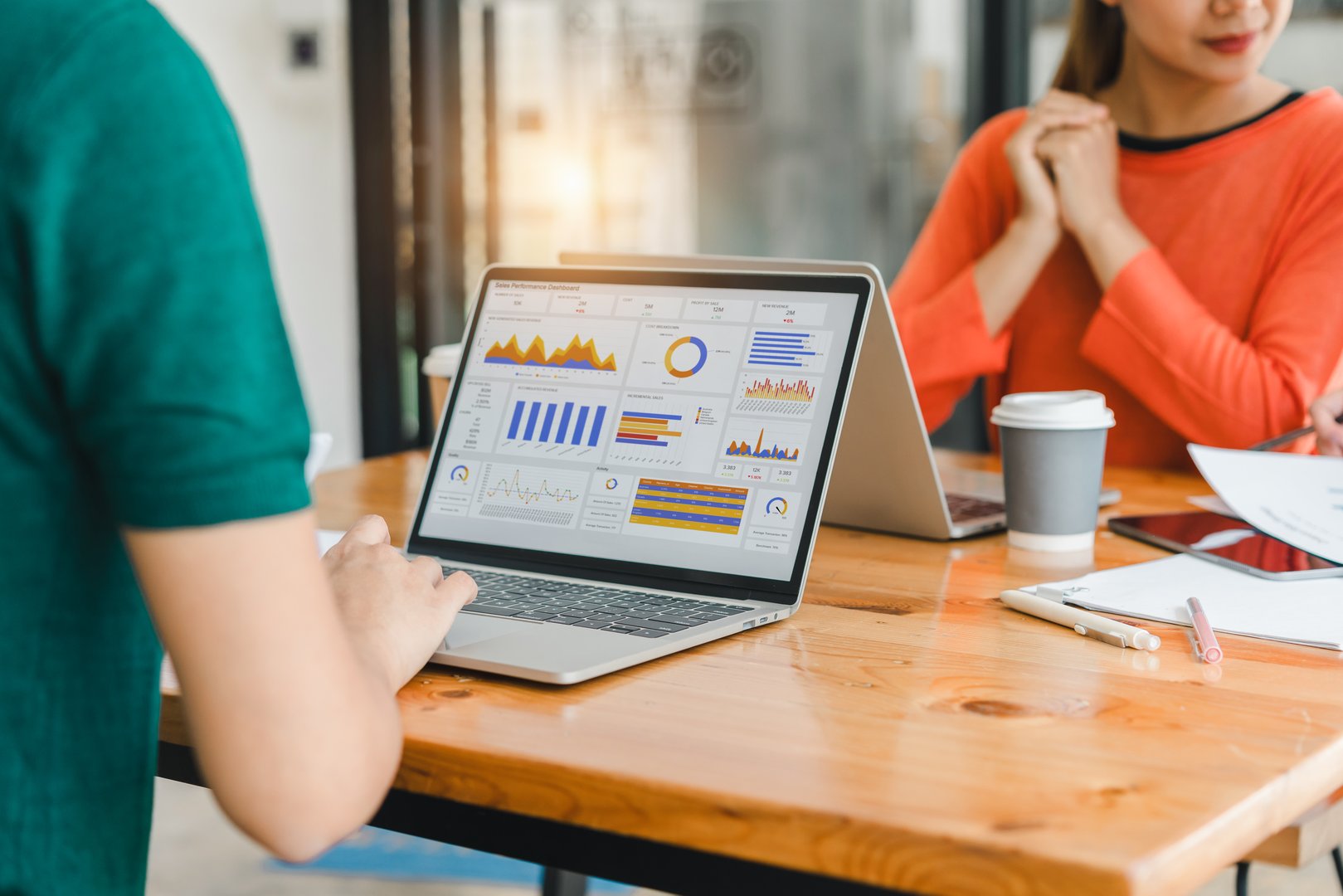 A person interacts with a digital sales dashboard displaying various performance metrics and analytics