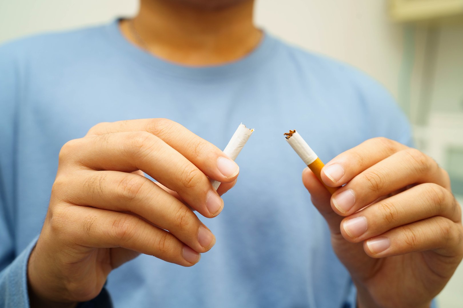 Quit smoking, Asian man breaking destroy cigarette in hand.