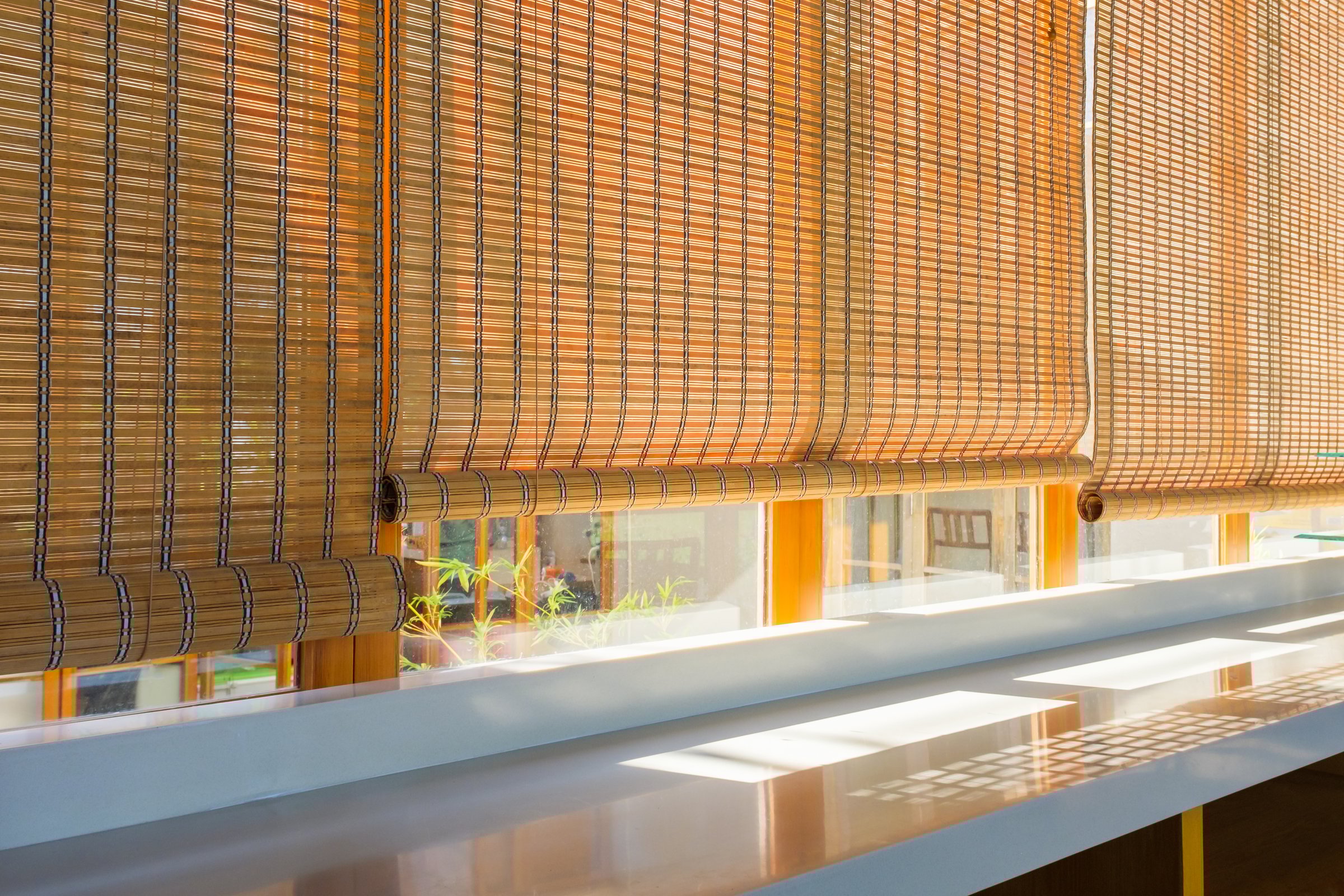 Bamboo blinds and sunlight streaming into the room through the windows, vintage decoration in a modern room