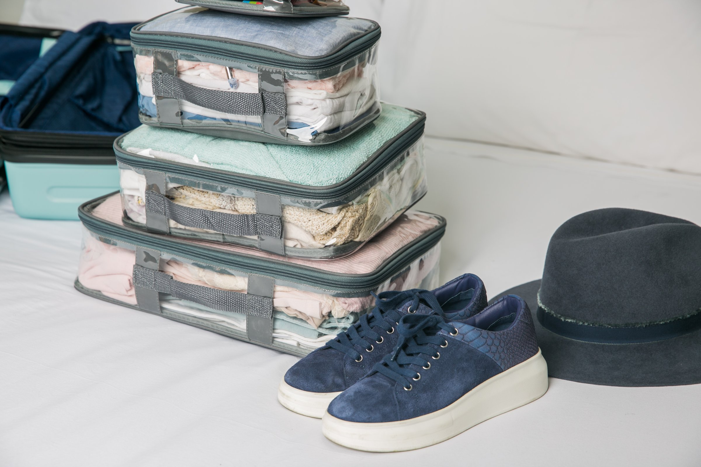 Woman packing for vacation using packing cubes in a suitcase