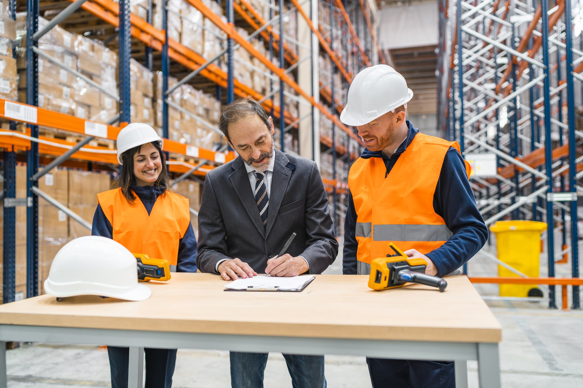 Entrepreneurial boss signing a contract with warehouse workers supervising in a logistics center