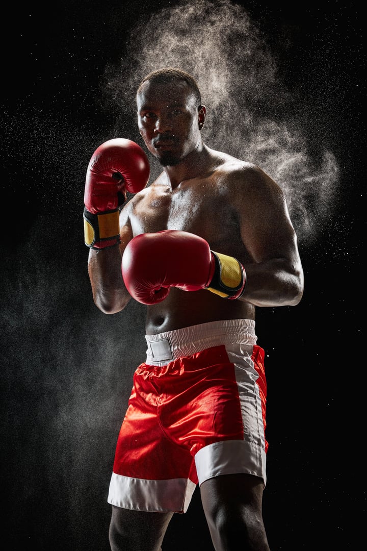 Determined African man, muscular athlete in boxing gear, focused and prepared for fight