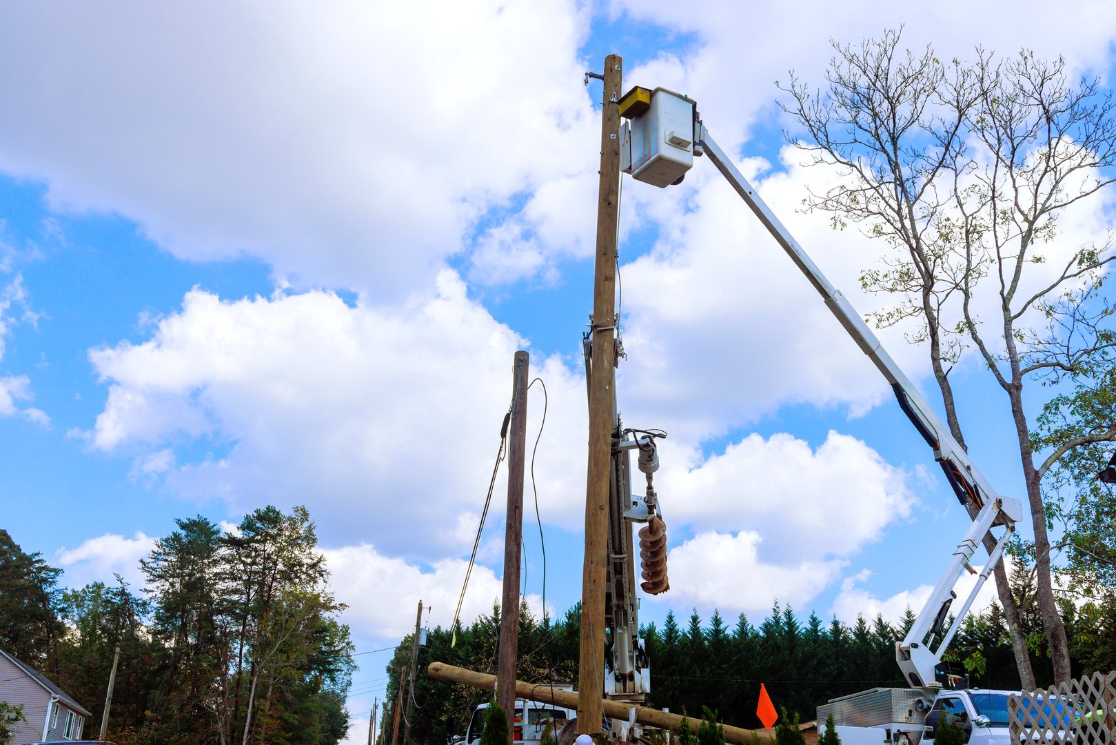 Electrical technician are using lifting platform to fix equipment on utility pole under works day