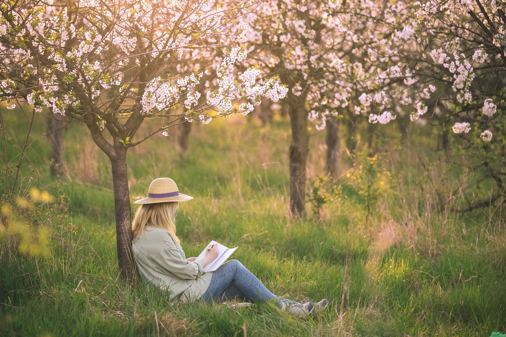 Woman writing in journal in nature