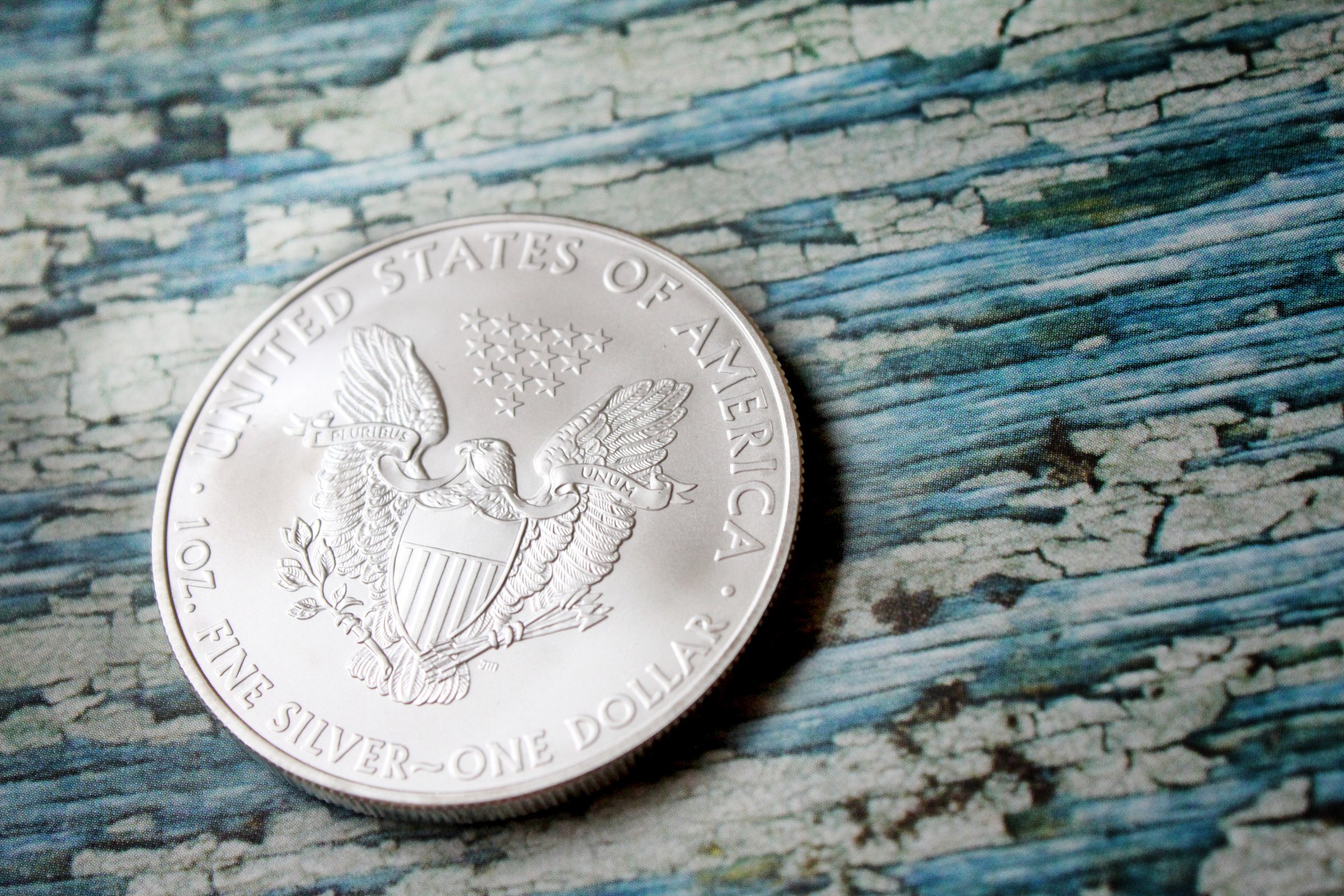 Obverse design is based on the U.S. "Walking Liberty" half dollar. The reverse side of the coin features a bald eagle and shield, with 13 stars, representing the 13 original American colonies, positioned above the eagle's head. 