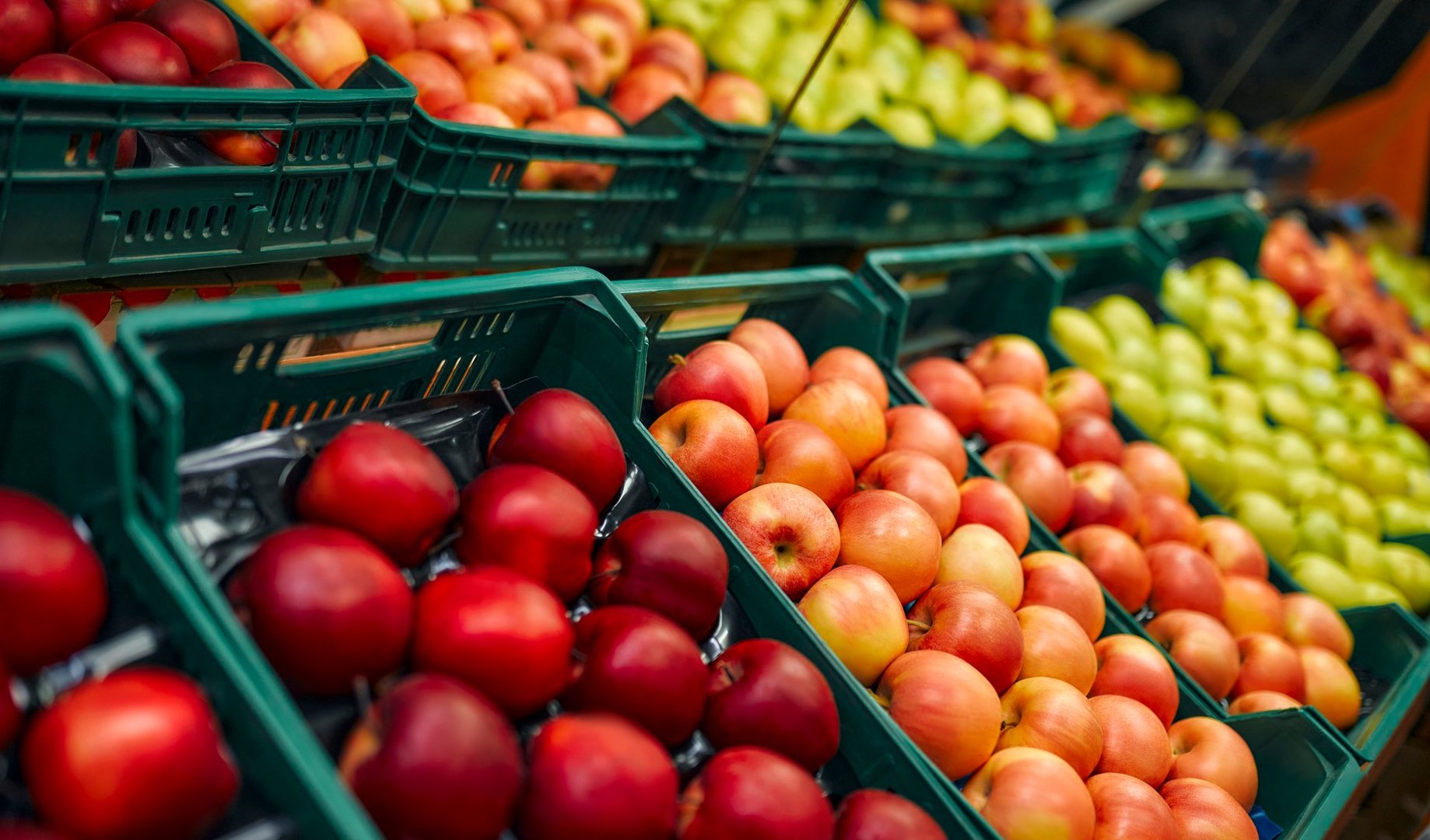 Crates of fresh fruit such as apples are for sale in the store. Buying vegetables and fruits at the market.