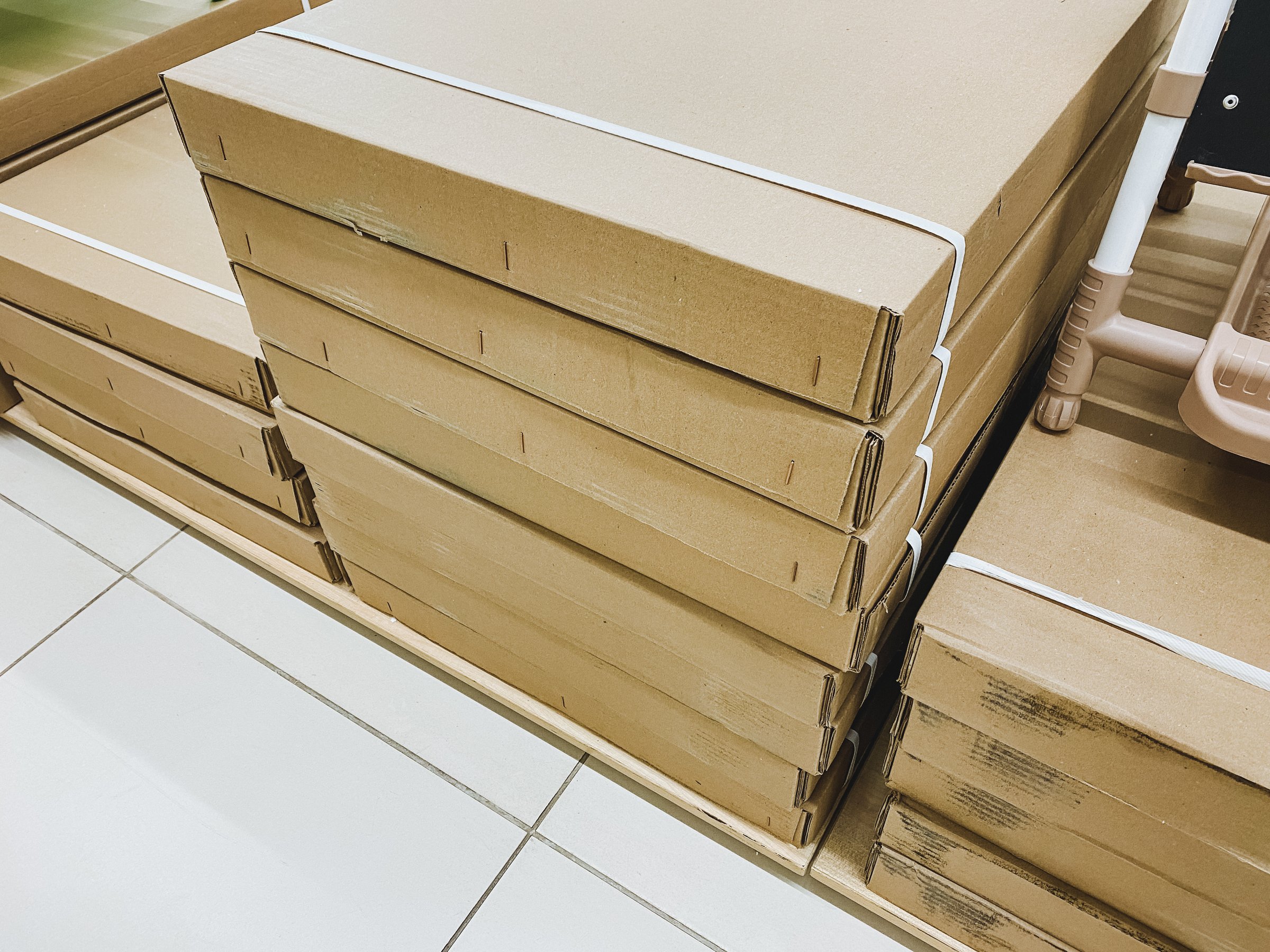 A meticulously wellorganized stack of sturdy cardboard boxes is neatly arranged and positioned on a robust shelf that securely supports them while keeping everything orderly and accessible for use
