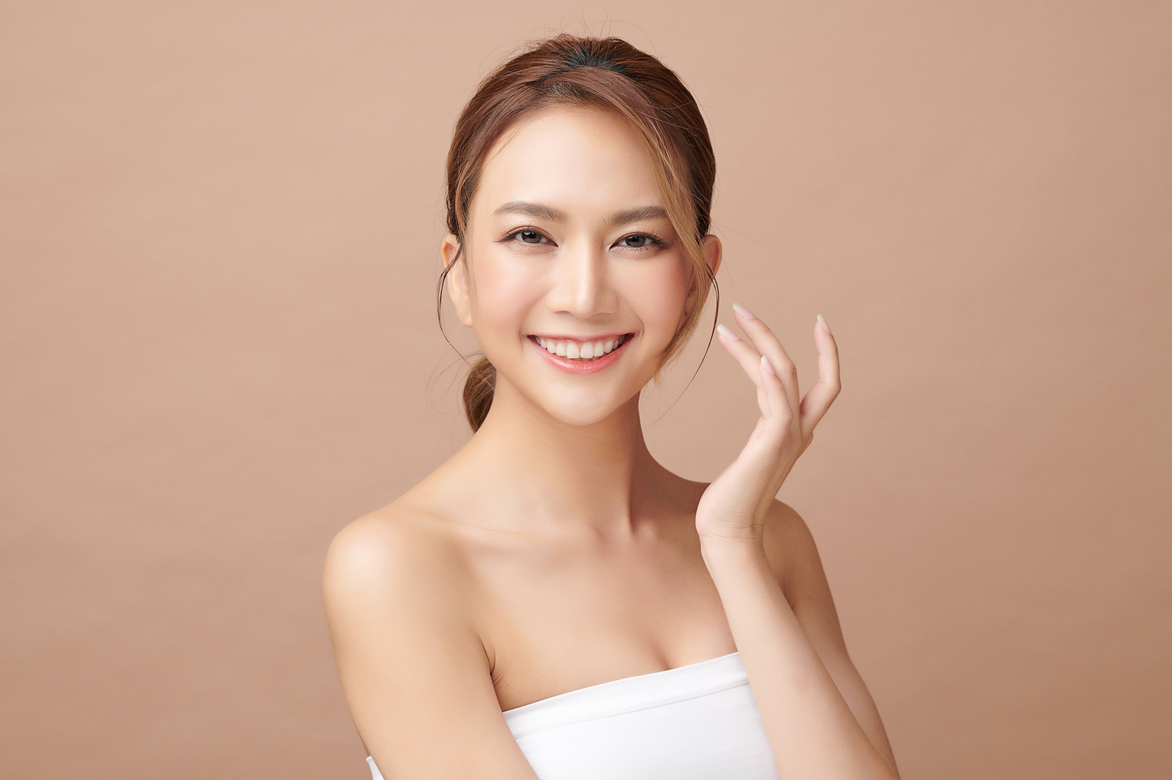 Beautiful young asian woman with clean fresh skin on beige background, Face care, Facial treatment, Cosmetology, beauty and spa, Asian women portrait.