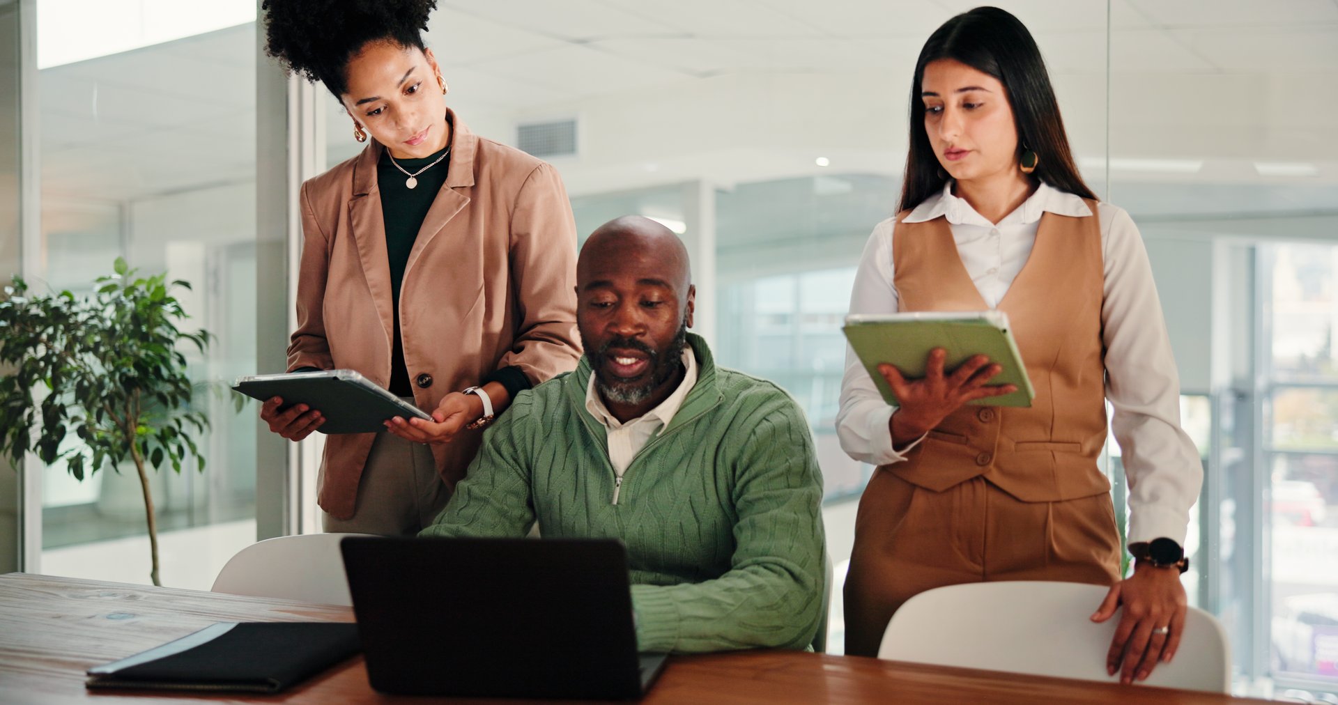 Man, women and staff with laptop, office meeting and discussion with brainstorming at media agency. People, editor and journalist with review, feedback and tablet for article development at company