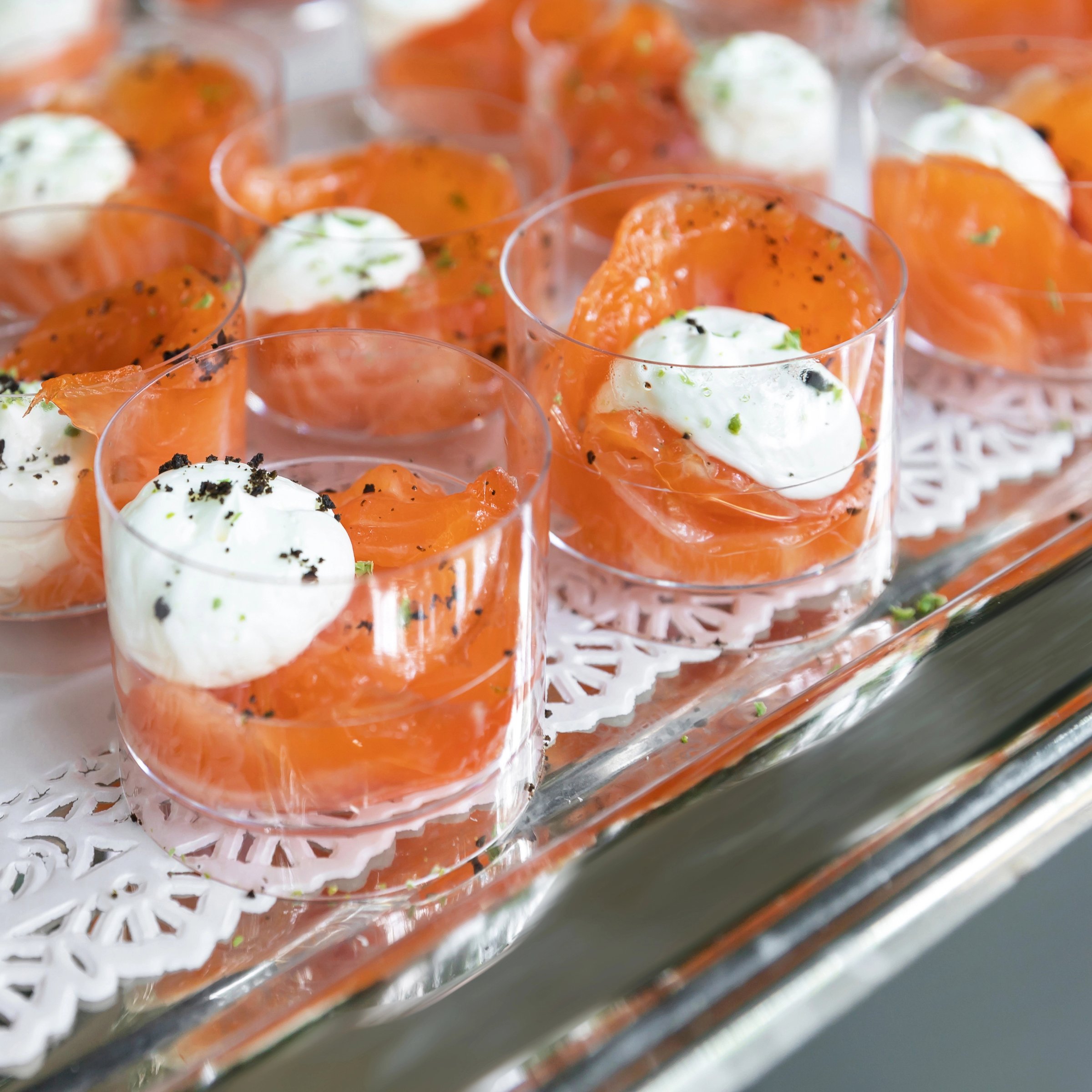Glasses filled topped with smoked salmon and cream cheese served as appetizer for a party or an event.